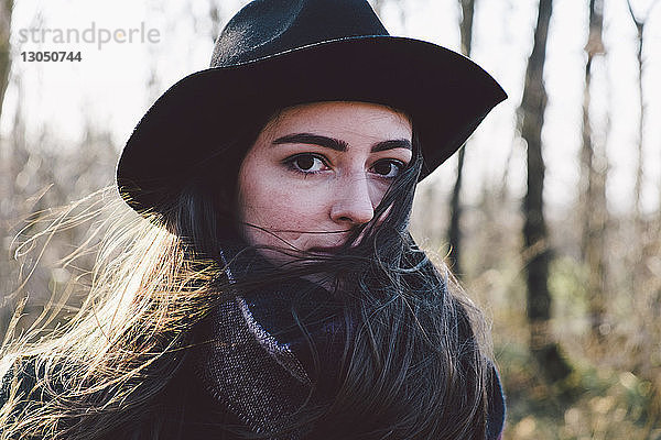Porträt einer selbstbewussten jungen Frau mit Hut im Park
