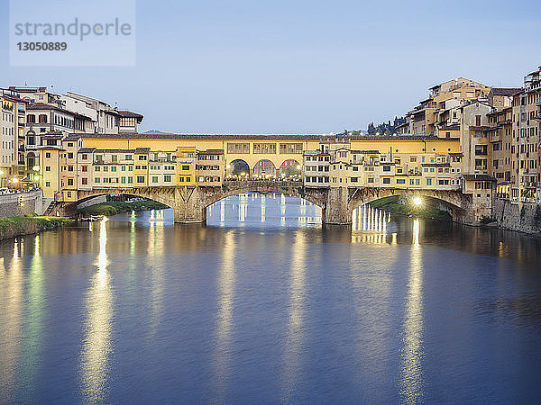 Ponte vecchio über dem Fluss Arno in der Stadt gegen den Himmel in der Abenddämmerung