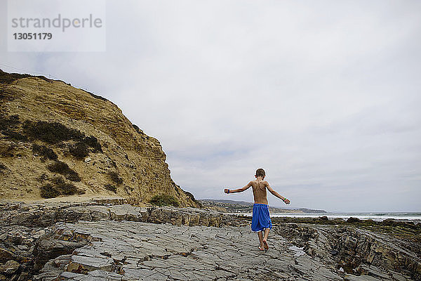 Rückansicht eines Jungen am Strand von Corona del Mar gegen den Himmel