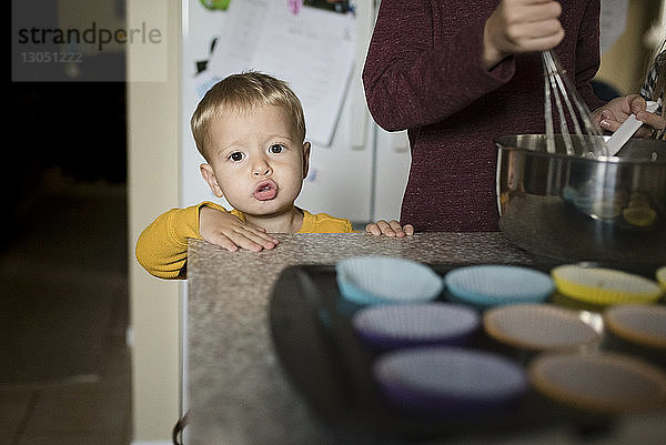 Porträt eines süßen Jungen  der neben einem Bruder steht  der in der Küche Essen zubereitet