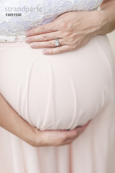 Bauch berührender Mittelteil einer schwangeren Frau