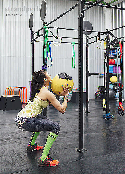 Sportler  der mit Medizinball im Fitnessstudio trainiert