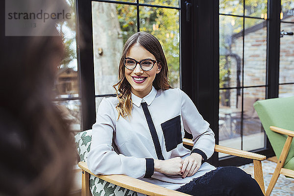 Ausgeschnittenes Bild einer Frau  die mit einer Kollegin im Café diskutiert