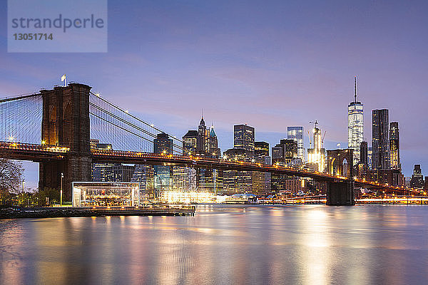 Brooklyn Bridge über den East River in der Stadt gegen den Himmel in der Abenddämmerung