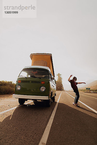 Mann auf Autoreise Skateboard fahren mit Lieferwagen  Ventura  Kalifornien  USA