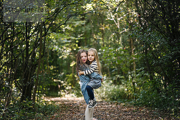 Schwestern umarmen sich im Wald