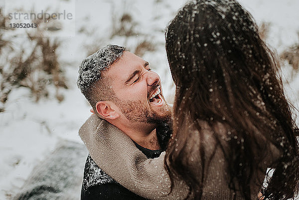 Lachendes Paar in verschneiter Landschaft