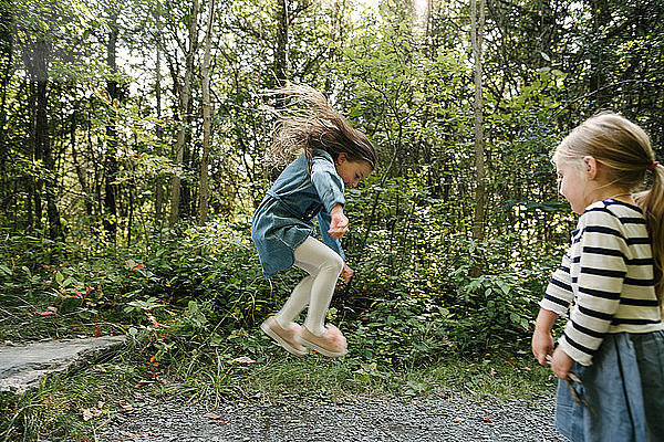 Schwestern spielen im Wald