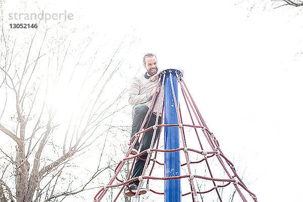 Mann auf der Spitze eines Spinnennetzturms im Park