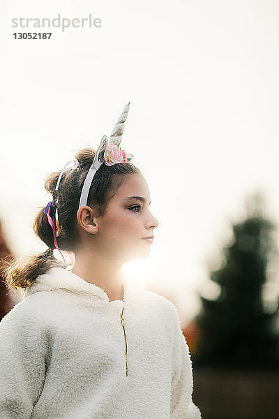 Mädchen mit Einhorn-Haarband im Park