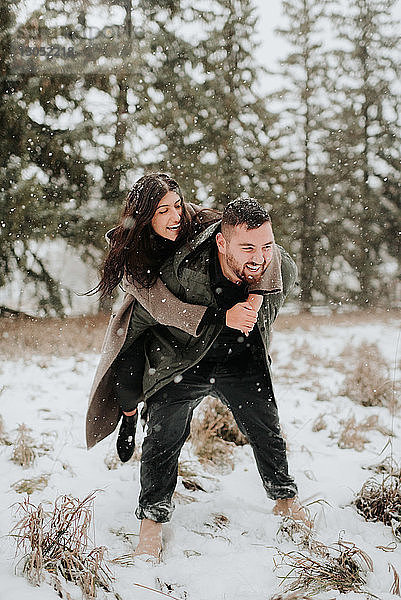 Paar spielt Huckepack in verschneiter Landschaft  Georgetown  Kanada