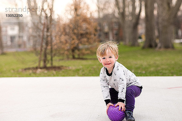 Junge spielt Ball im Park