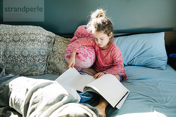 Kleines Mädchen liest im Bett