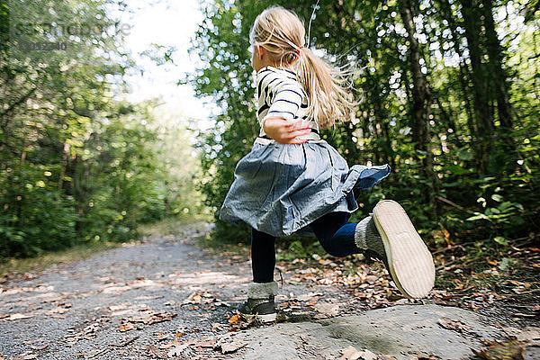 Kleines Mädchen rennt im Wald