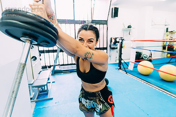 Weibliche Boxerin beim Heben von Gewichten