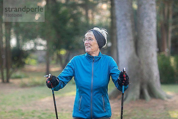 Ältere Frau beim Nordic Walking im Park