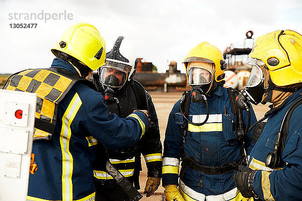 Ausbildung von Feuerwehrleuten  Feuerwehrleute mit Atemschutzgerät  die dem Vorgesetzten zuhören