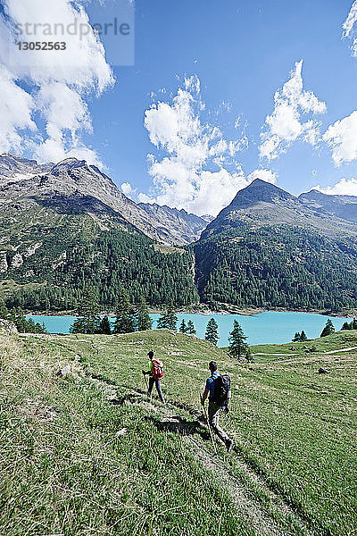 Wanderer auf saftig grünem Feld  See im Hintergrund  Mont Cervin  Matterhorn  Wallis  Schweiz