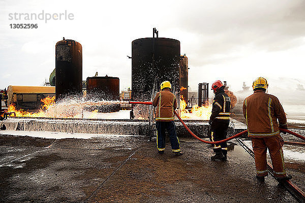 Ausbildung von Feuerwehrleuten  Sprühen von Feuerlöschschaum auf den Brand eines Öllagertanks in einer Ausbildungseinrichtung