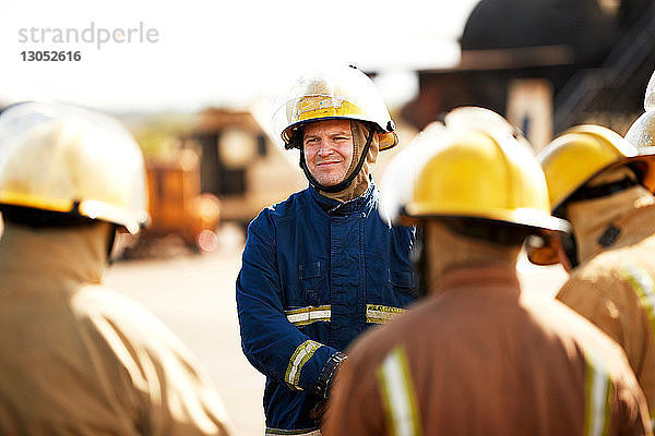 Ausbildung von Feuerwehrleuten  Feuerwehrmänner hören dem Vorgesetzten in der Ausbildungseinrichtung zu  Blick über die Schulter