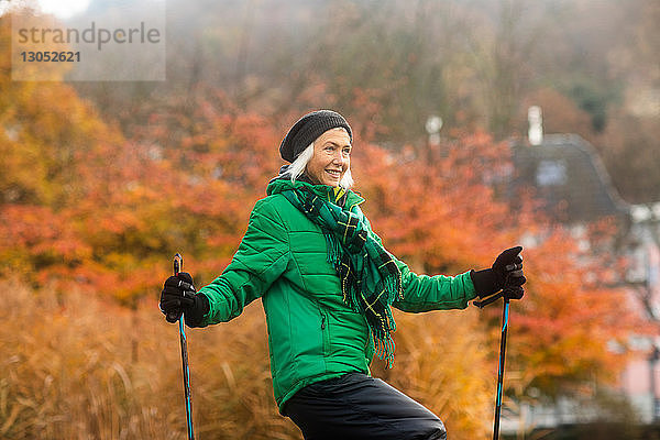 Reife Frau beim Nordic Walking im Park