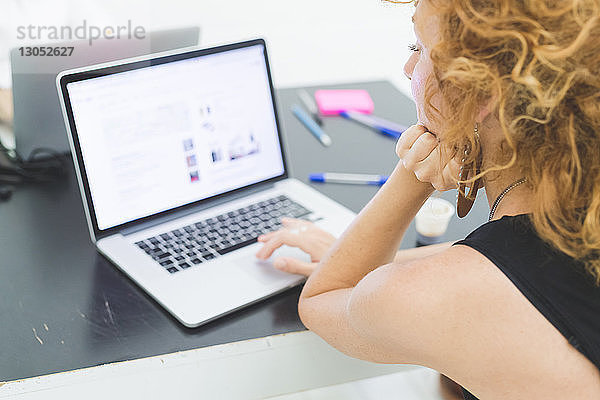 Geschäftsfrau tippt am Laptop am Büroschreibtisch  Blick über die Schulter