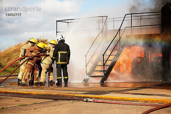 Ausbildung von Feuerwehrleuten  Feuerwehrmänner sprühen Wasser an der Treppe der Ausbildungseinrichtung