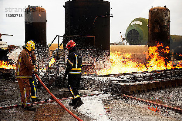 Ausbildung von Feuerwehrleuten  Sprühen von Feuerlöschschaum auf den Brand eines Öllagertanks in einer Ausbildungseinrichtung