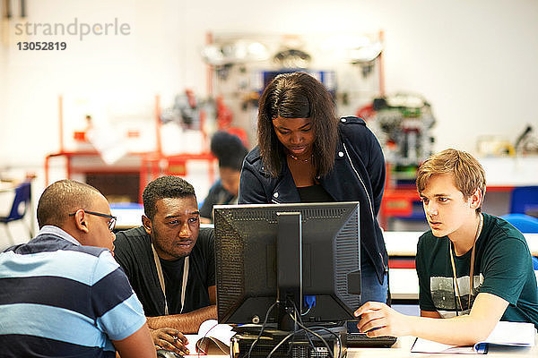 Männliche und weibliche Hochschulstudenten schauen im College-Klassenzimmer auf den Computer
