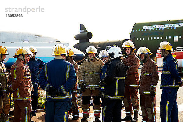 Ausbildung von Feuerwehrleuten  große Gruppe von Feuerwehrleuten hört dem Vorgesetzten zu