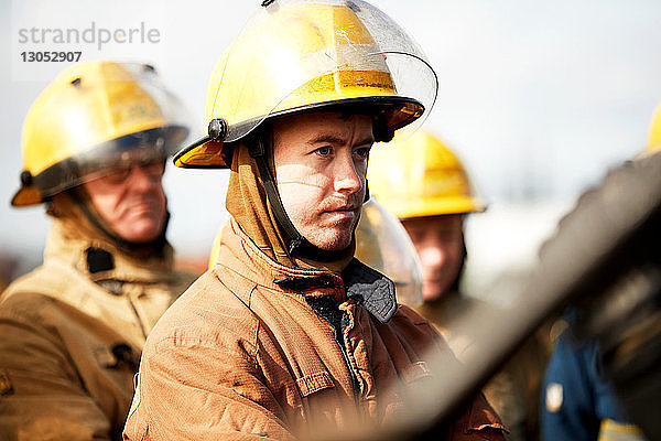 Ausbildung von Feuerwehrleuten  kleine Gruppe von Feuerwehrleuten  die den Anweisungen zuhören