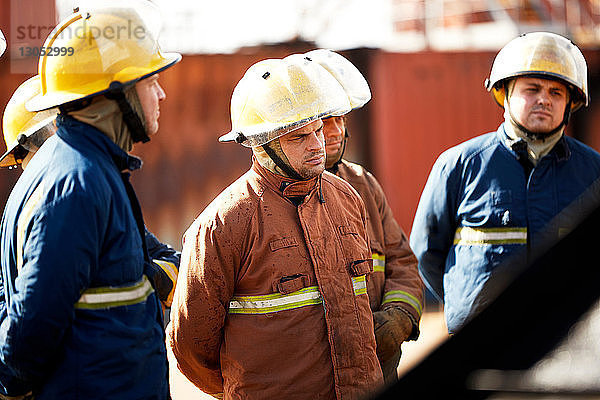 Ausbildung von Feuerwehrleuten  Team von Feuerwehrleuten  die dem Vorgesetzten in der Ausbildungseinrichtung zuhören