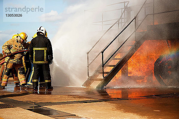 Ausbildung von Feuerwehrleuten  Feuerwehrmänner sprühen Wasser an der Treppe der Ausbildungseinrichtung