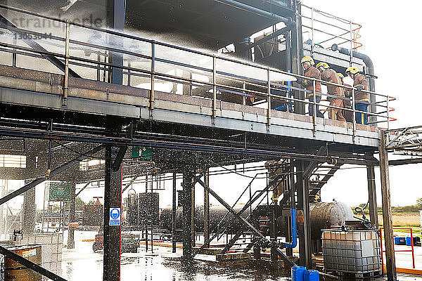 Ausbildung von Feuerwehrleuten  am Gebäude der Ausbildungseinrichtung  die Wasser versprüht