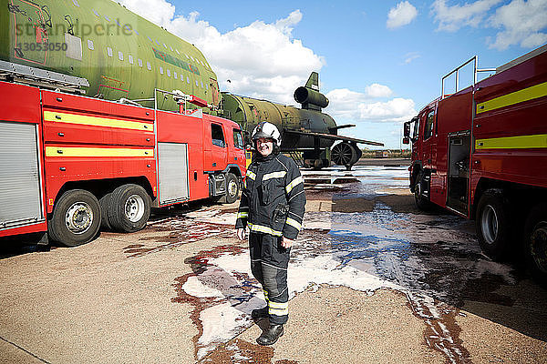 Feuerwehrausbildung  Feuerwehrmann mit Feuerwehrautos in der Ausbildungsstätte  Porträt