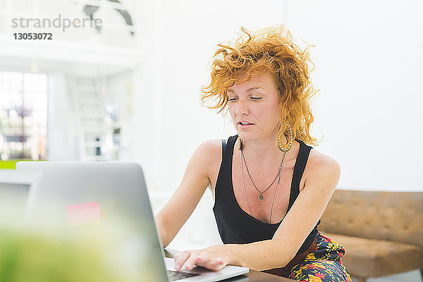 Geschäftsfrau tippt am Laptop am Büroschreibtisch
