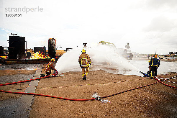 Ausbildung von Feuerwehrleuten  Sprühen von Wasser auf Feuer in der Ausbildungsstätte