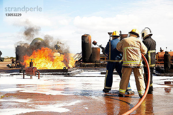 Ausbildung von Feuerwehrleuten  Feuerwehrmänner bereiten sich darauf vor  den Brand eines Öllagertanks in der Ausbildungsstätte zu löschen