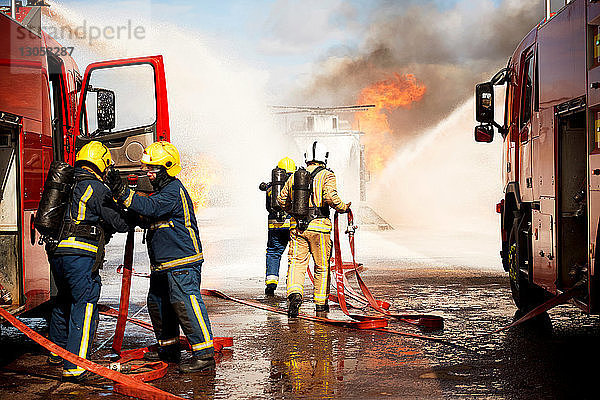 Ausbildung von Feuerwehrleuten  Team von Feuerwehrleuten löscht Scheinhubschrauberfeuer in der Ausbildungsstätte