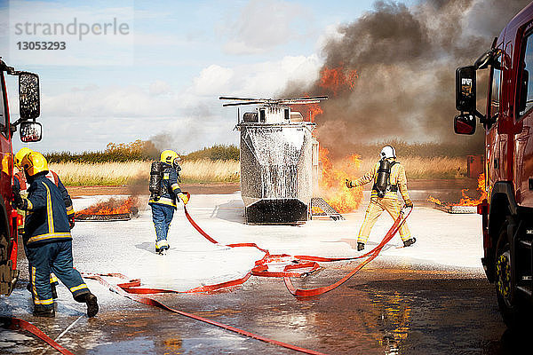 Ausbildung von Feuerwehrleuten  Team von Feuerwehrleuten löscht Scheinhubschrauberfeuer in der Ausbildungsstätte