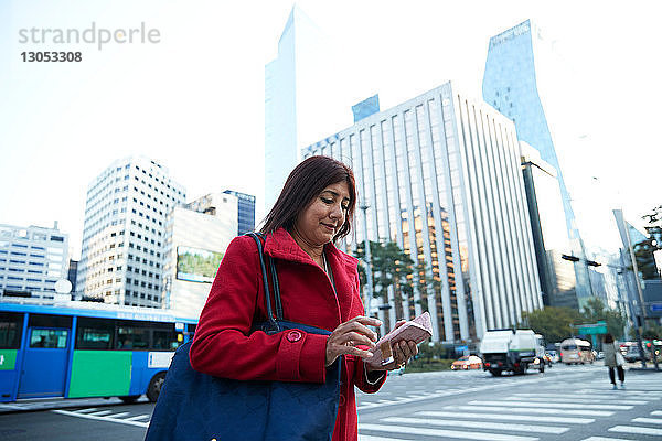 Geschäftsfrau mit Smartphone in der Stadt  Seoul  Südkorea