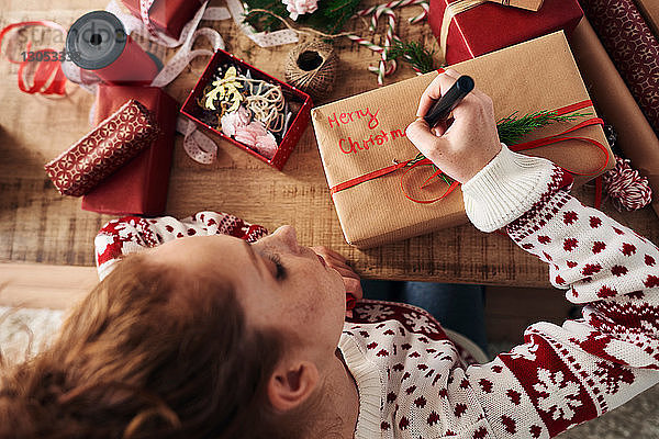 Frau schreibt Grüsse auf Weihnachtsgeschenke