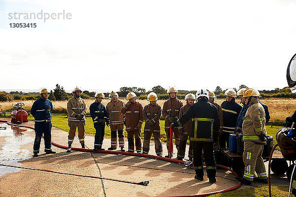 Ausbildung von Feuerwehrleuten  Team von Feuerwehrleuten  die dem Vorgesetzten in der Ausbildungseinrichtung zuhören