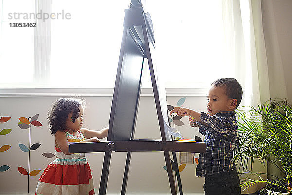 Kinder malen zu Hause an der Staffelei