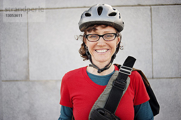 Porträt einer Frau mit Fahrradhelm gegen Gebäude