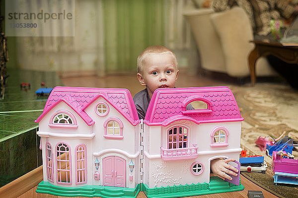 Porträt eines Jungen mit rosa Spielhaus zu Hause