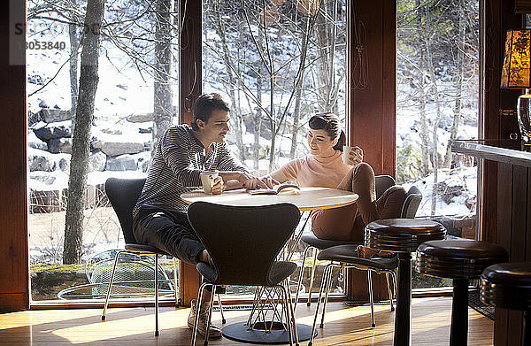 Paar liest Buch  während es im Café sitzt