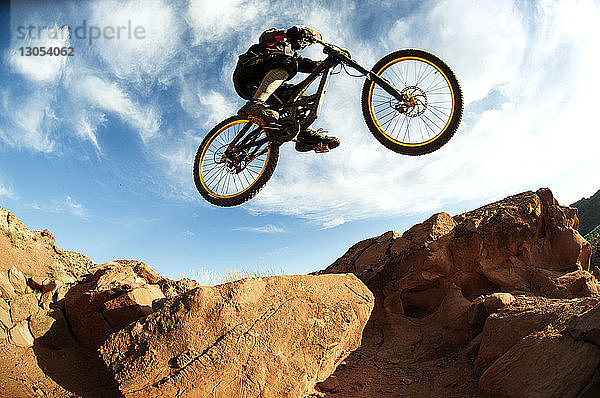 Mountainbiker beim Stunt in der Luft gegen den Himmel