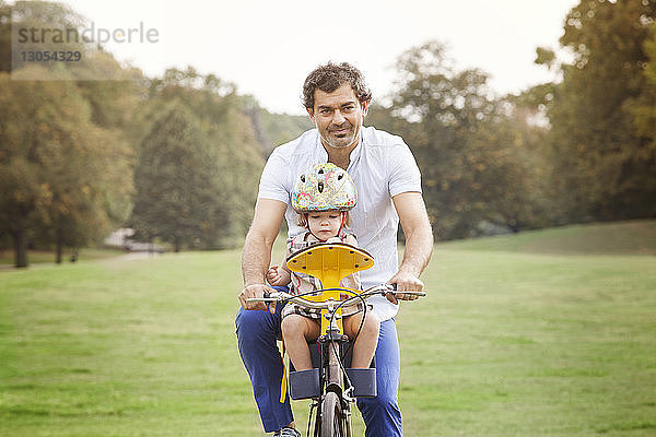 Vater mit Tochter beim Fahrradfahren im Park