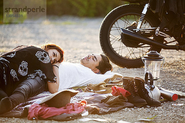 Paar entspannt auf Schotterstraße mit dem Motorrad